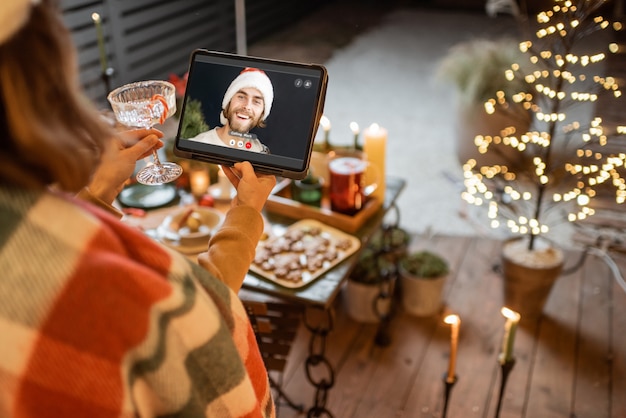 Woman having a video call with a friend during a New Year celebration. Concept of video communication during self-isolation and quarantine for the holidays