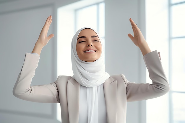 A woman in a headscarf with her hands up in the air