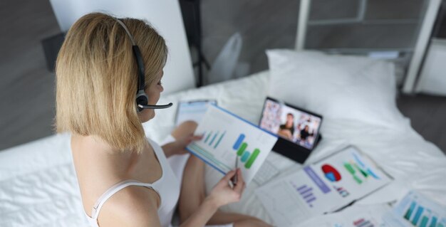 Photo woman in headset working with documents at home