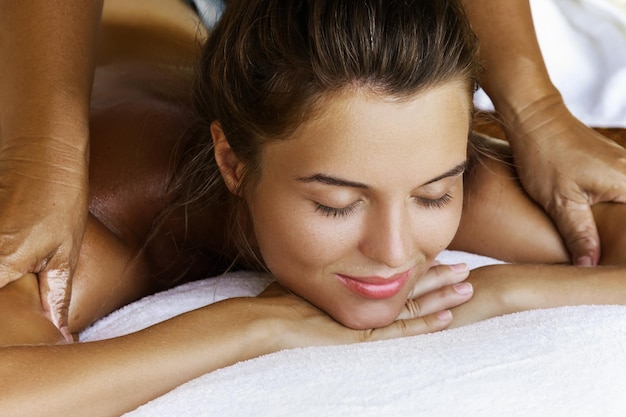 Woman during healing back massage therapy in Asian traditional clinic