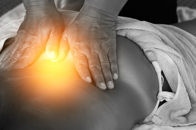 Woman during healing back massage therapy in Asian traditional clinic