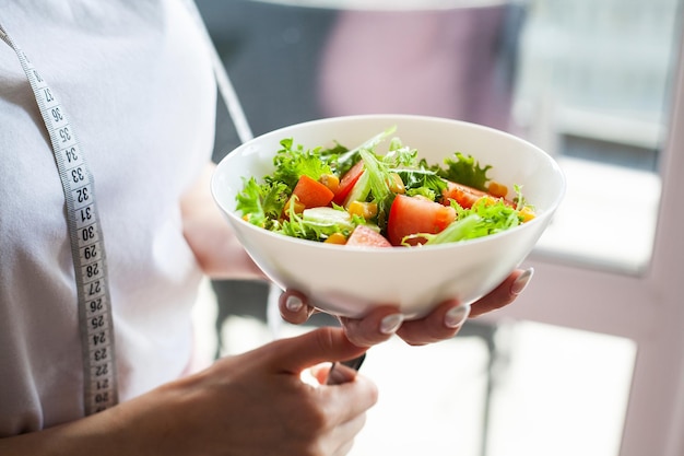 A woman on a healthy diet is holding a diet salad