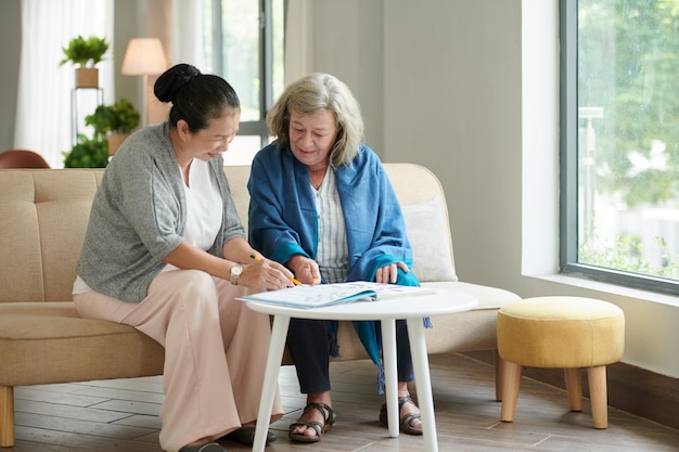 Woman Helping Friend to Solve Crossword