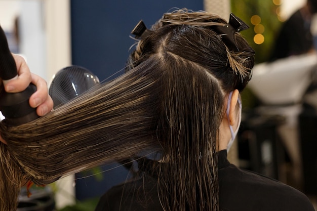 Woman on her back in hairdresser's salon with hair parted for drying