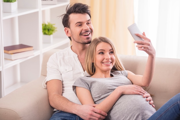 Woman and her husband are photographing themselves.