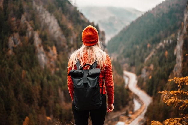 Woman hiker sits and enjoys valley view from viewpoint Hiker reached top of the mountain and relaxes Slovakia mala fatra Adventure and travel in the mountains region