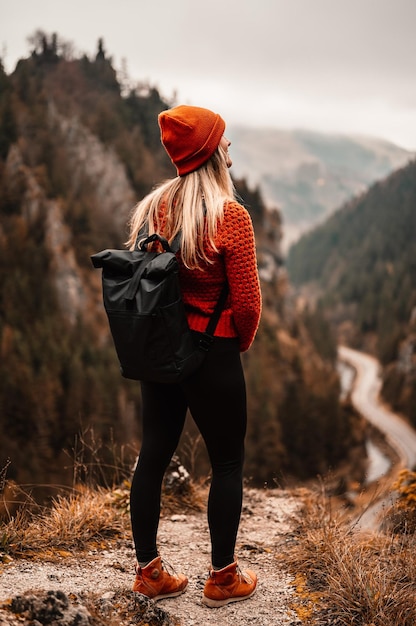 Woman hiker sits and enjoys valley view from viewpoint Hiker reached top of the mountain and relaxes Slovakia mala fatra Adventure and travel in the mountains region