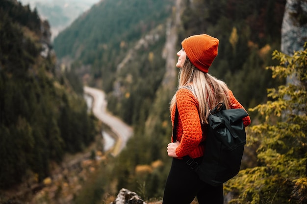 Woman hiker sits and enjoys valley view from viewpoint Hiker reached top of the mountain and relaxes Slovakia mala fatra Adventure and travel in the mountains region