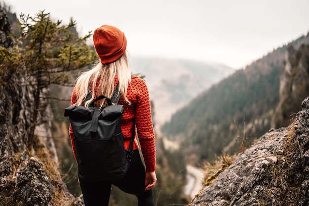 Woman hiker sits and enjoys valley view from viewpoint Hiker reached top of the mountain and relaxes Slovakia mala fatra Adventure and travel in the mountains region