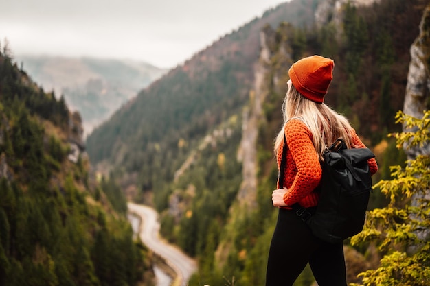 Woman hiker sits and enjoys valley view from viewpoint Hiker reached top of the mountain and relaxes Slovakia mala fatra Adventure and travel in the mountains region