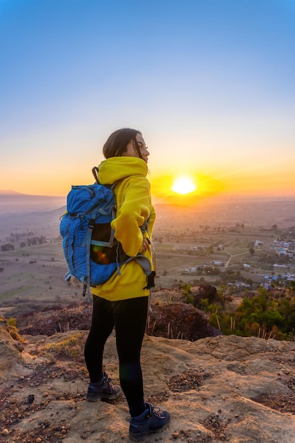 Woman hiking in the mountains and looking at the sun a panoramic view