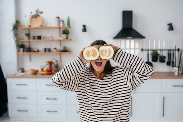 Woman hold cut fruit at eye level instead of glasses