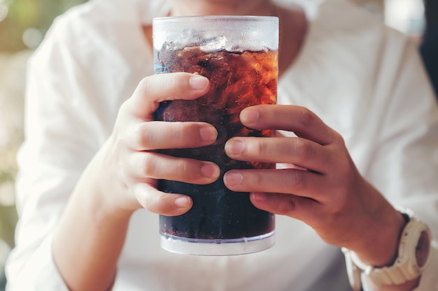 Woman hold a glass with soft drinks 