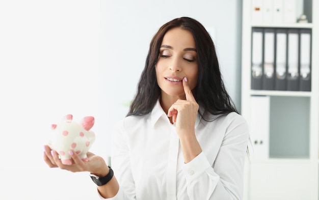 Woman hold piggybank think of better way to use money saving up for future