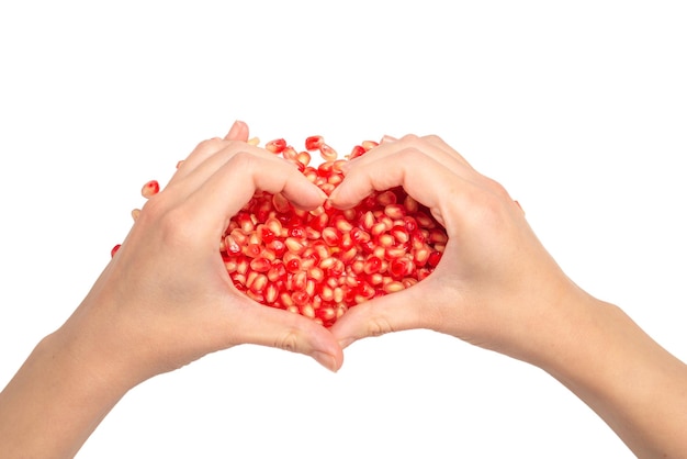 Woman hold pomegranate seeds Heart symbol isolated on white