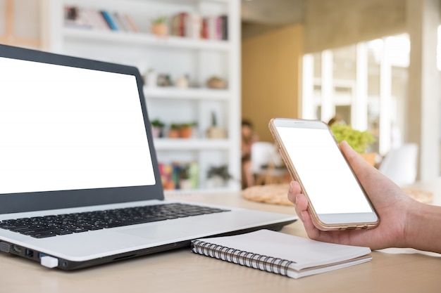 Woman hold smartphone - mock up woman used smartphone and lapotp on the desk copyspace, business working and freelance, concept