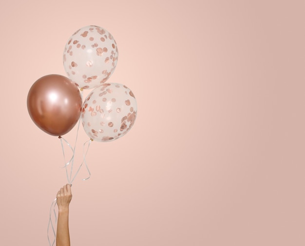 Woman hold three transparent and pink balloons isolated on beige with  space for text greeting card