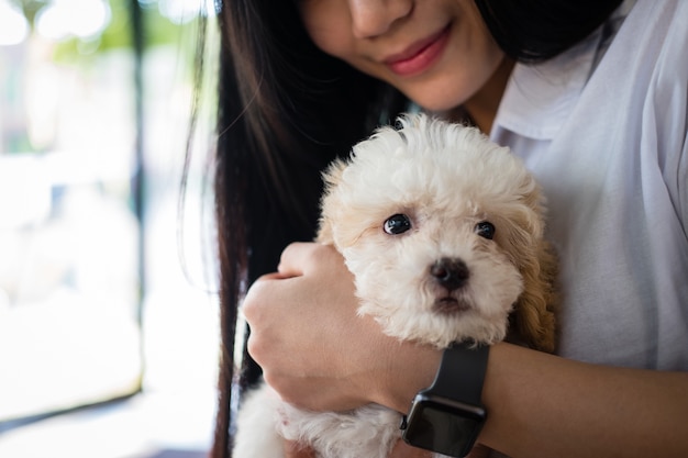 woman holding adorable dog. teenager with pet at home.