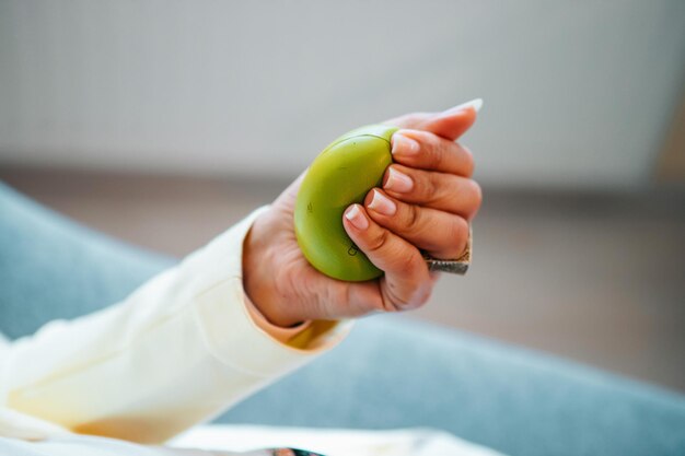 Woman holding antistress ball during procedure in clinic