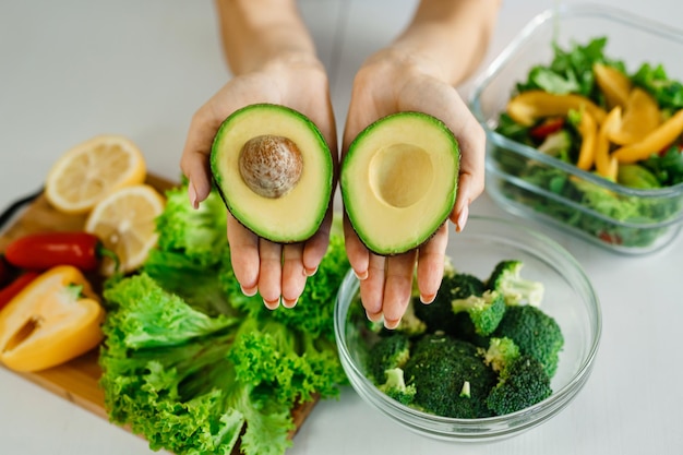 Woman holding avocado closeup Healthy eating conceptNutrition lessons