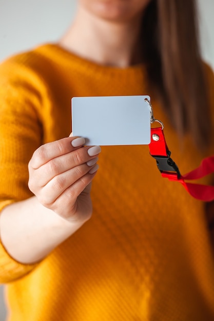 Woman holding badge name tag, with blank space mock up