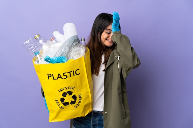 Woman holding a bag full of plastic bottles to recycle