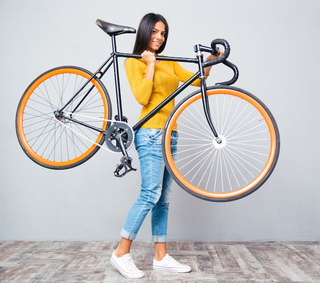 Woman holding bicycle on shoulder