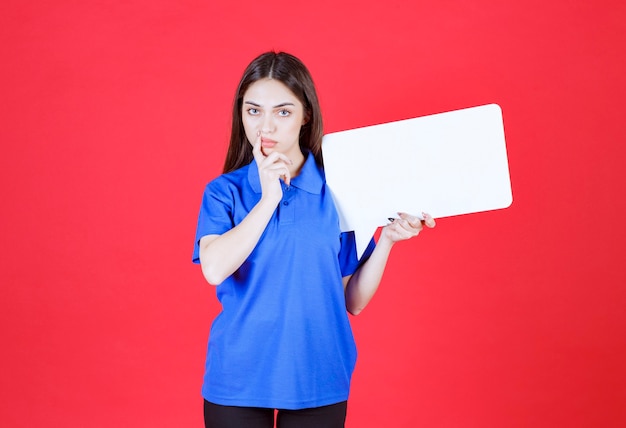 woman holding a blank rectangle info board and looks confused and thoughtful. 