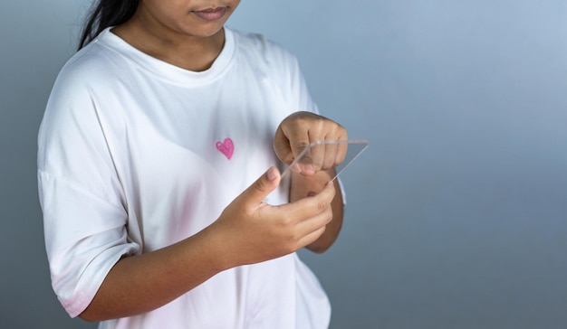 Woman holding a blank screen phone mockup transparent acrylic used for displaying text or advertis.