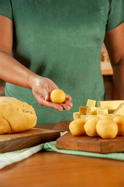 Woman holding brazilian cheese stuffed croquette bolinha de queijo on a wooden table