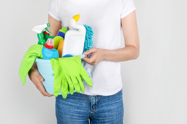 Woman holding bucket with cleaning products