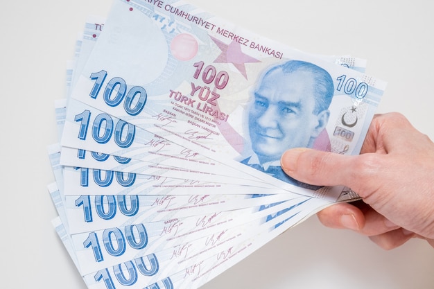 Woman holding a bunch of 100 Turkish Lira banknotes