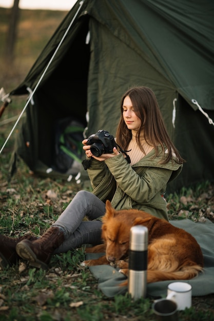 Woman holding camera near tent