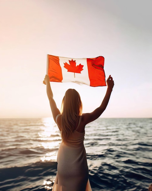 A woman holding a canadian flag in front of a body of water.