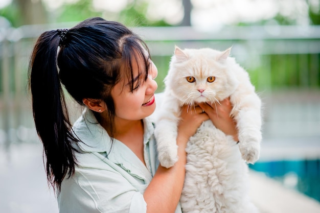 Woman holding cat playing at home with love for cats The smile glints in his bond with his fluffy pet cat The relationship of people and cats cat owners domestic cats fat cats