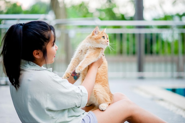 Woman holding cat playing at home with love for cats The smile glints in his bond with his fluffy pet cat The relationship of people and cats cat owners domestic cats fat cats