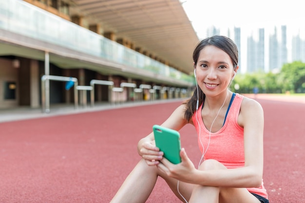 Woman holding cellphone to check the training program