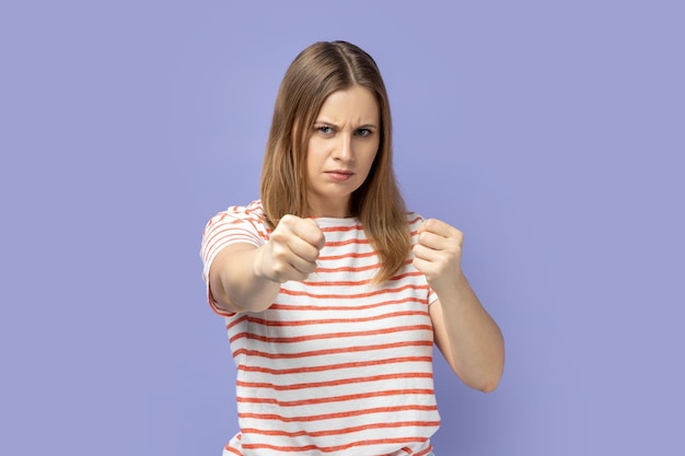 Woman holding clenched fists up fighting with abuser defence from domestic violence