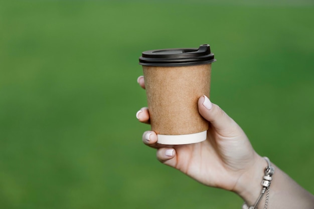 Woman holding coffee in paper cup