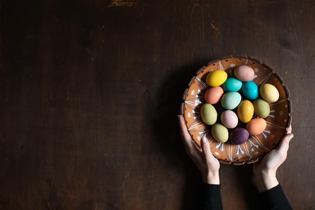 Woman holding colorful Easter eggs in her hands Space for text