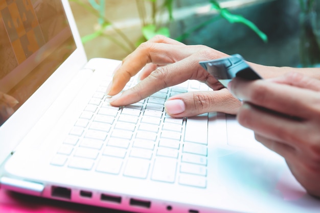 Woman holding credit card on laptop. Online shopping, Online banking concept