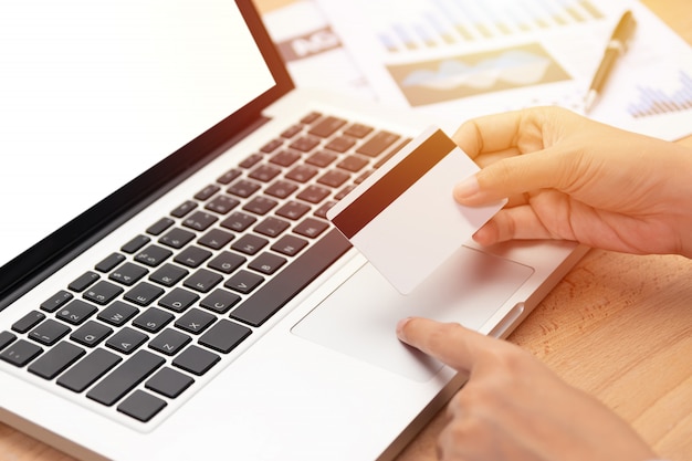 woman holding a credit card and purchase making online payment via computer