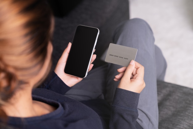 Woman holding credit card and smartphone