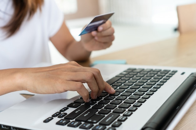 Woman holding credit card and using computer laptop, account and saving concept.