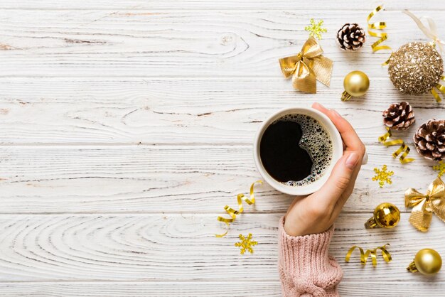 Photo woman holding cup of coffee woman hands holding a mug with hot coffee winter and christmas time concept