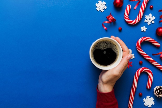 Photo woman holding cup of coffee woman hands holding a mug with hot coffee winter and christmas time concept