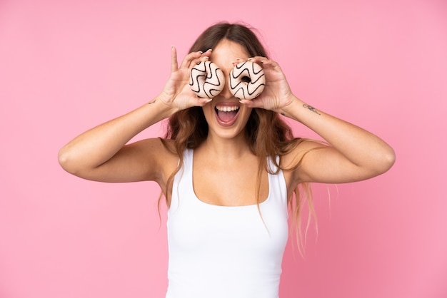 Woman holding donuts over isolated wall