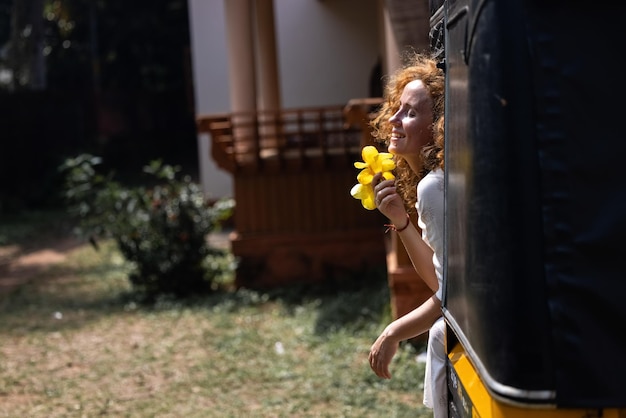 A woman holding a flower in her hand