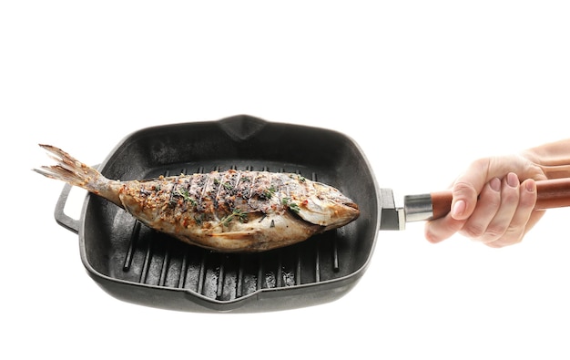 Woman holding frying pan with delicious prepared fish on white background