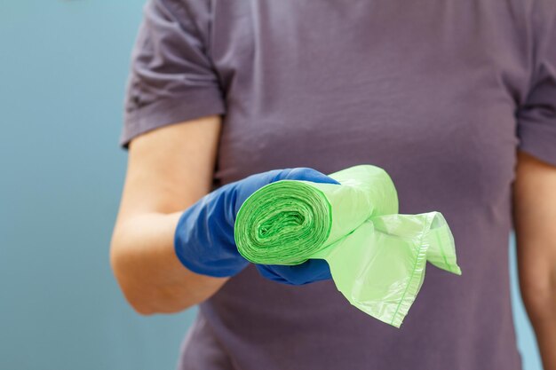 Woman holding garbage bags on a blue background